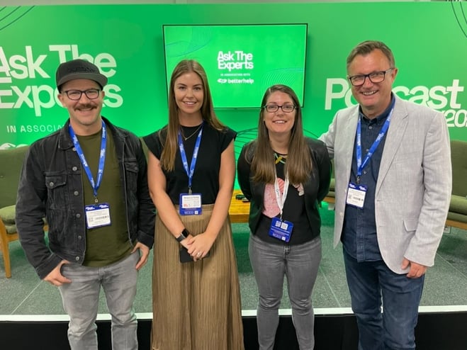 A group of people standing in front of a green screen
Description automatically generated