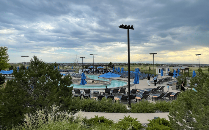 A pool with umbrellas and chairs
Description automatically generated