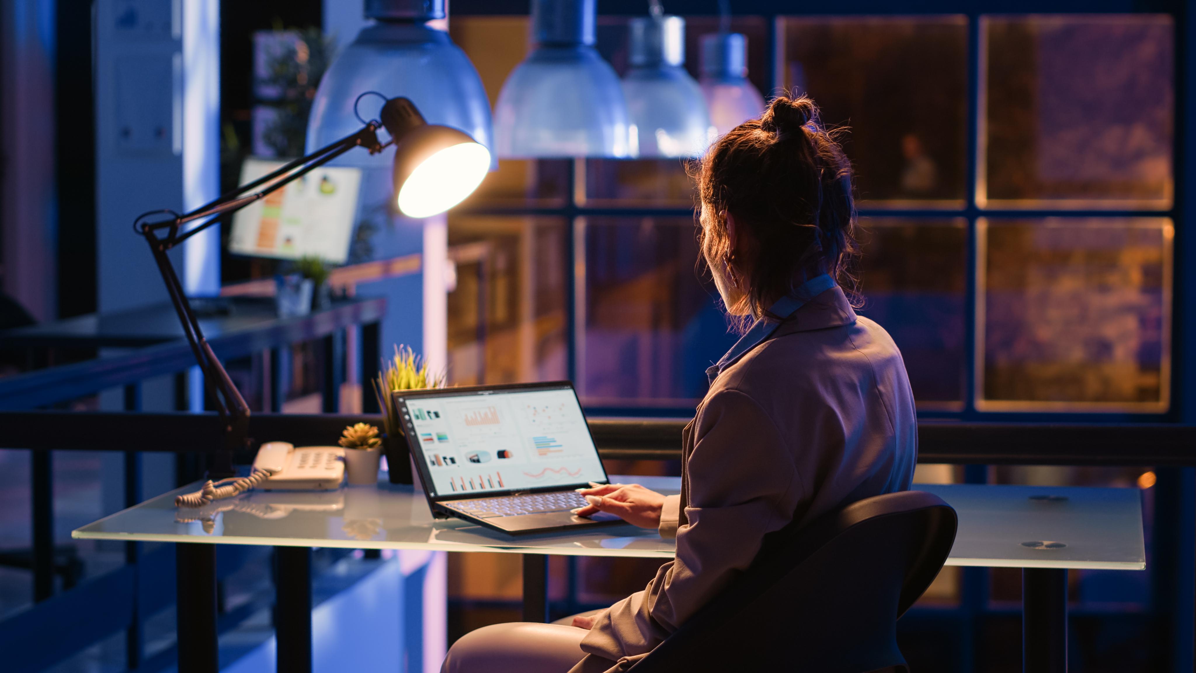Mujer trabajando en una laptop gestionando la distribución de campañas publicitarias de audio y la generación de ingresos